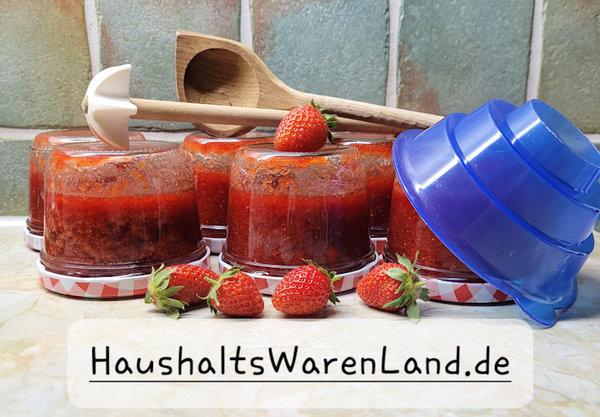 Marmeldadengläser mit eingekochter Erdbeermarmelade und Einfülltrichter, Quirl und Holzlöffel